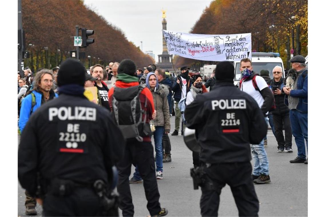 Teilnehmer der Demonstration potestieren nahe dem Brandenburger Tor. Foto: Paul Zinken/dpa