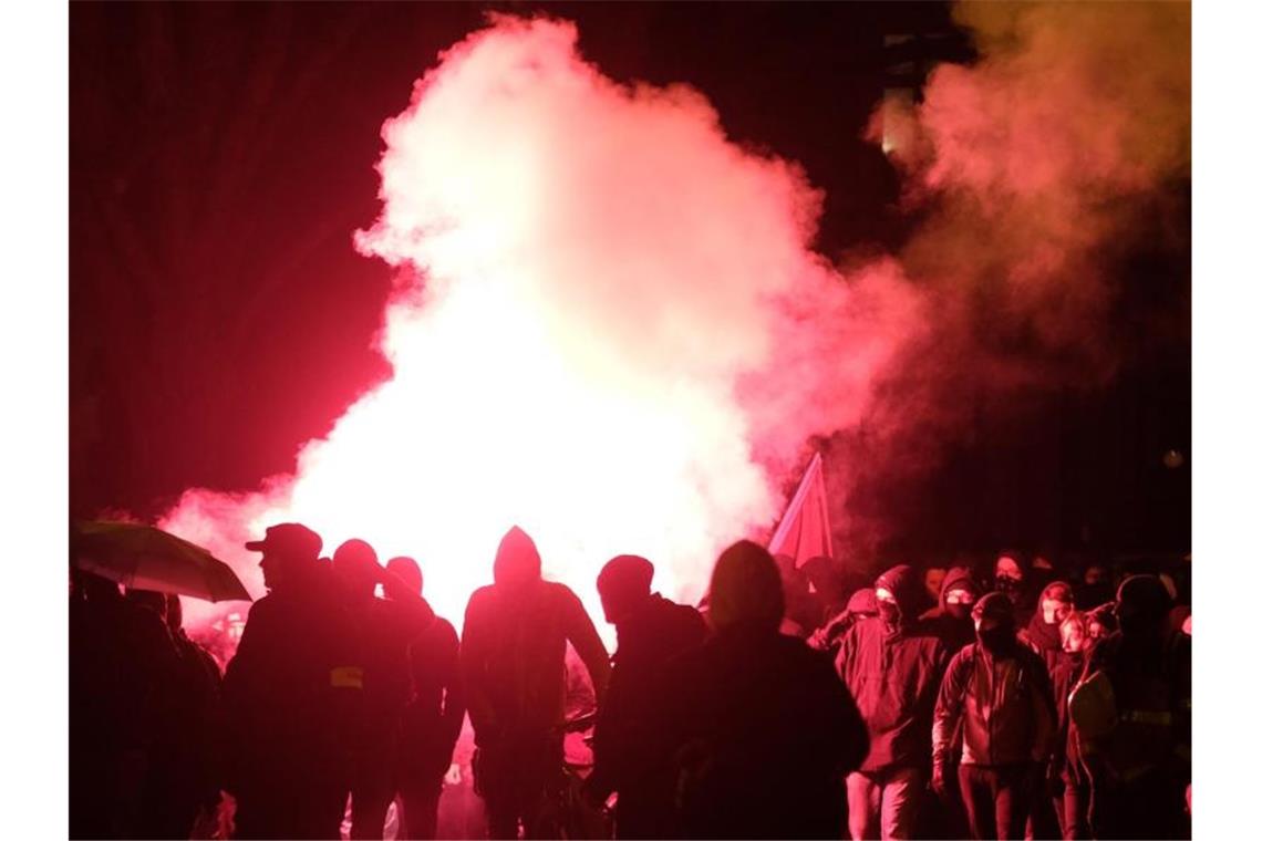 Teilnehmer der linken Demonstration zünden Pyrotechnik. Foto: Sebastian Willnow/dpa-Zentralbild/dpa