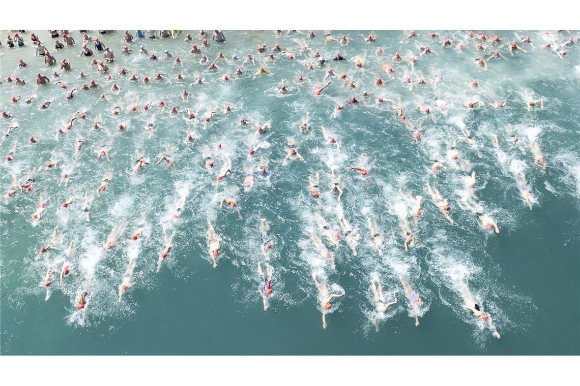 Teilnehmer der "Stadtzürcher Seeüberquerung" stürzen sich in Zürich bei hochsommerlichen Temperaturen in den Zürichsee.