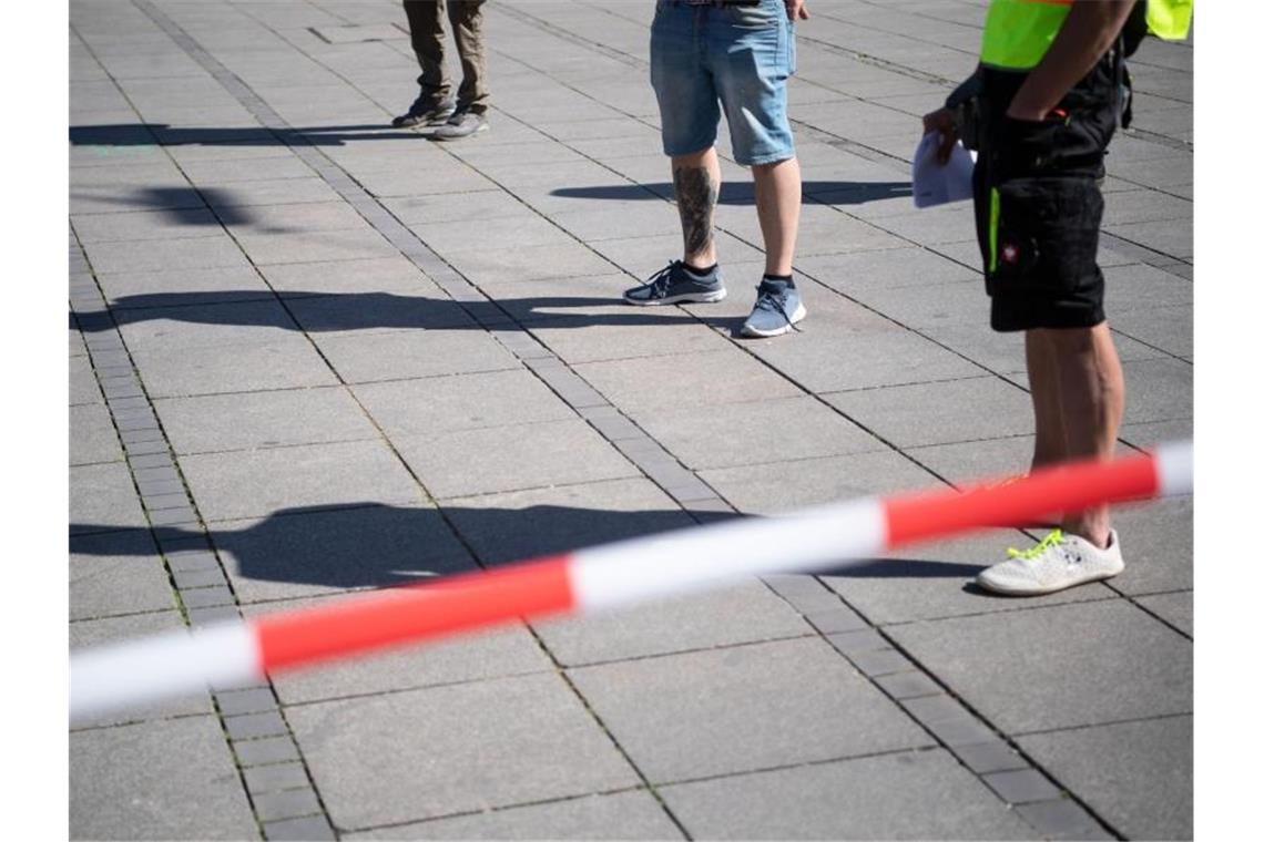 „Querdenken“: Initiative demonstriert für Grundrechte Teilnehmer einer Demonstration auf dem Schlossplatz stehen mit Abstand innerhalb einer Absperrung. Foto: Marijan Murat/dpa