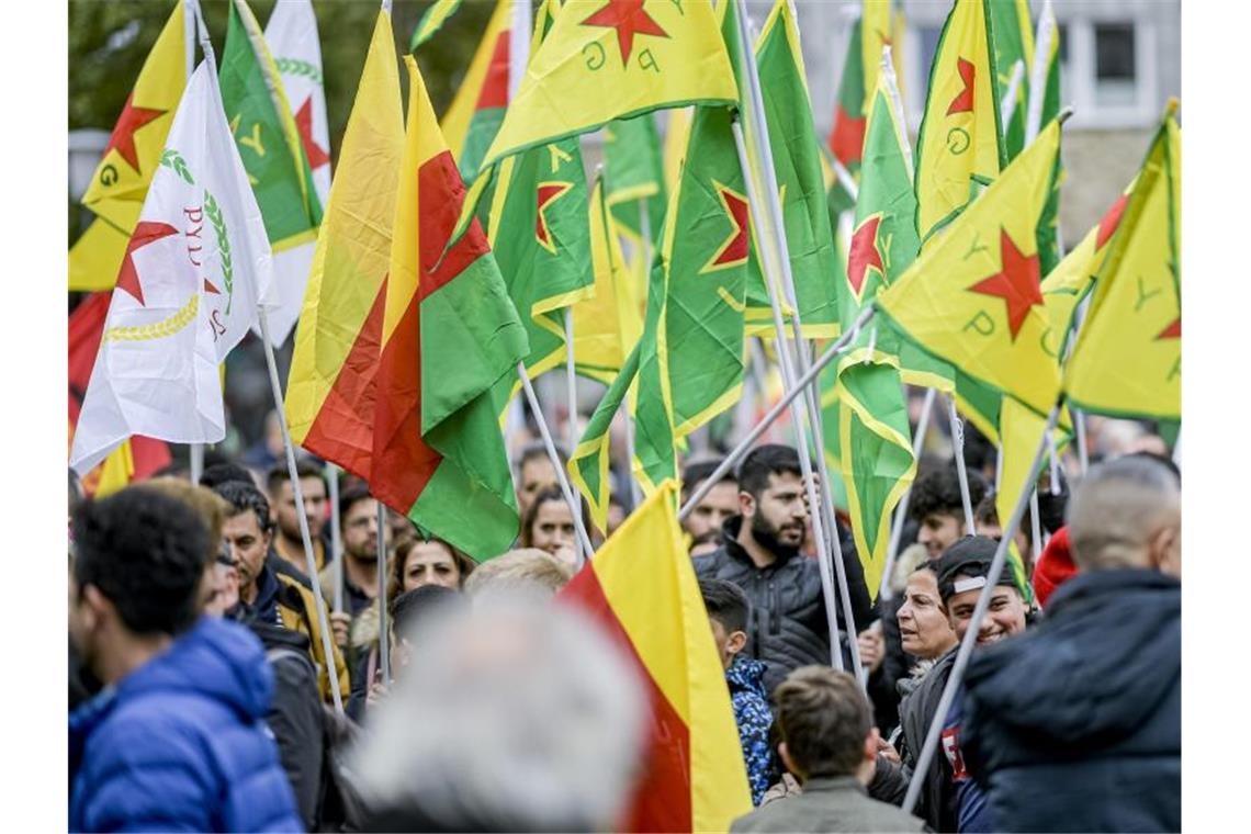 Teilnehmer einer Demonstration der Kurden schwenken Fahnen der YPG. Foto: Axel Heimken/dpa/Archivbild