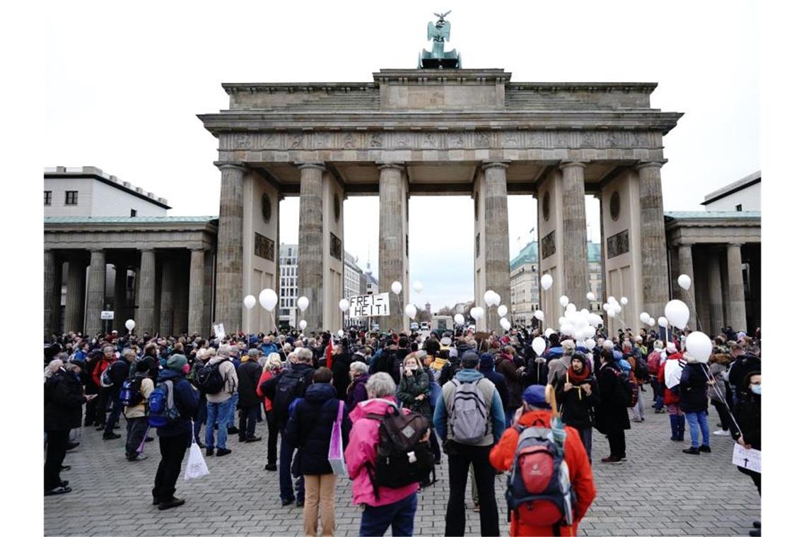 Teilnehmer einer Demonstration gegen die Corona-Einschränkungen der Bundesregierung stehen vor dem Brandenburger Tor. Foto: Kay Nietfeld/dpa