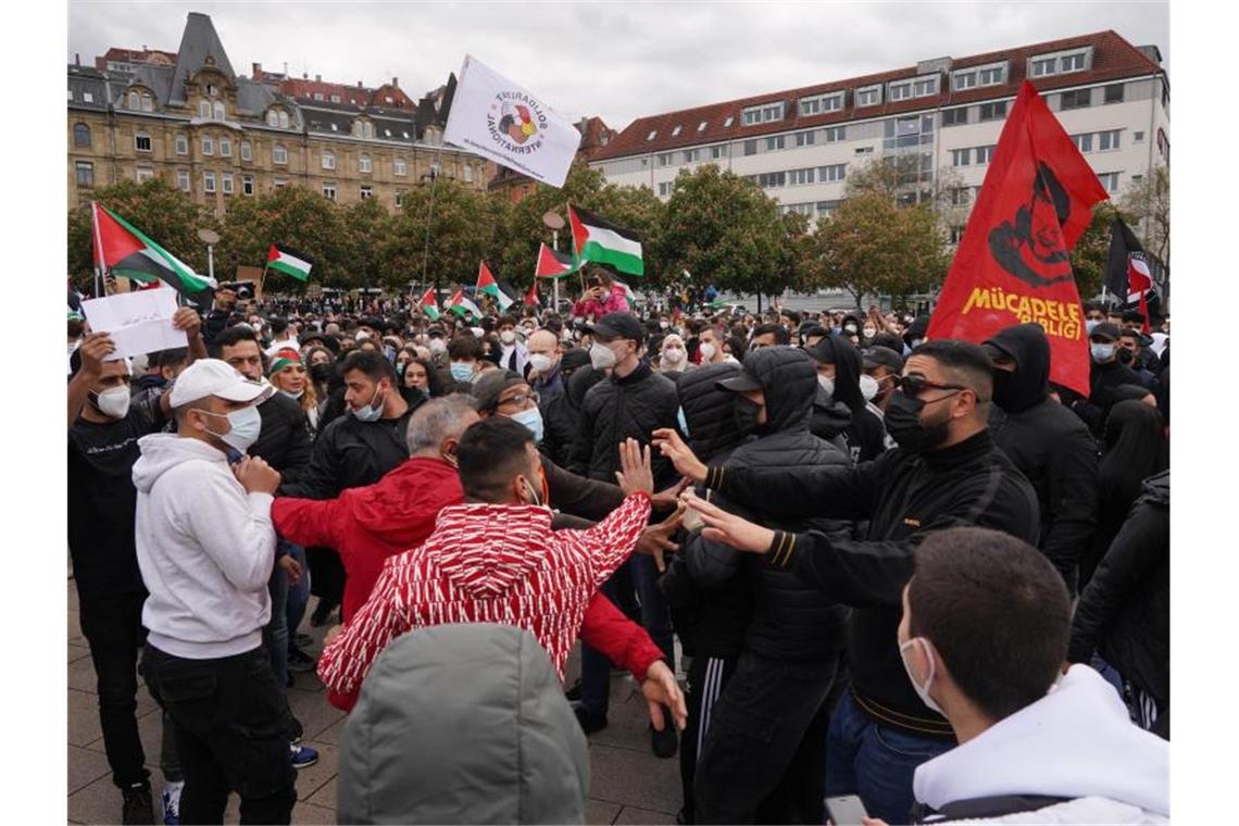 Proteste gegen Vorgehen Israels - Ausschreitungen in Berlin Teilnehmer einer pro-palästinensische Demonstration stehen auf dem Marienplatz in Stuttgart. Am Rande der Kundgebung kam es zu Rangeleien zwischen unterschiedlichen Gruppen und zwischen Demonstranten und der Polizei. Foto: Andreas Rosar/dpa