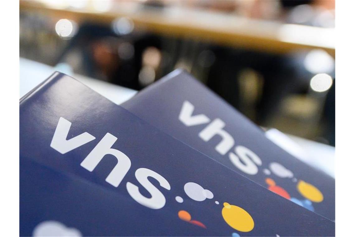 Millionen VHS-Kunden drohen höhere Gebühren Teilnehmer eines Sprachkurses sitzen hinter dem aktuellen Programm der Volkshochschule. Foto: Sebastian Gollnow