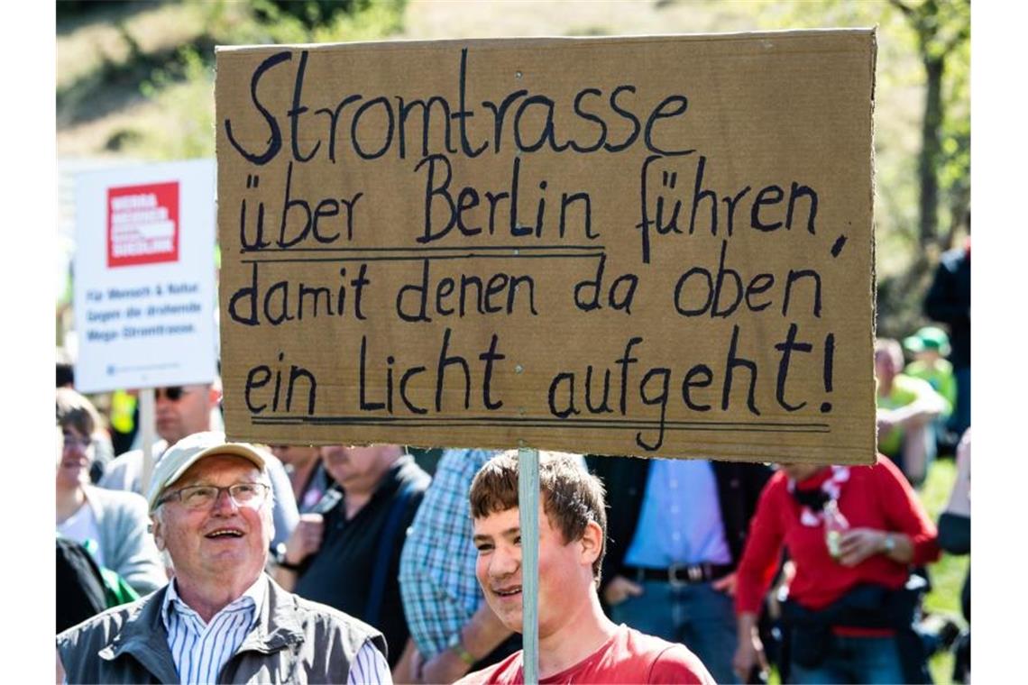 SPD-Umweltexperte: Widerspruch gegen Stromtrassen erschweren Teilnehmer mit Flaggen und Transparenten demonstrieren am Fuße der Brandenburg in Thüringen gegen die geplante Suedlink-Stromtrasse. Foto: Swen Pförtner/dpa