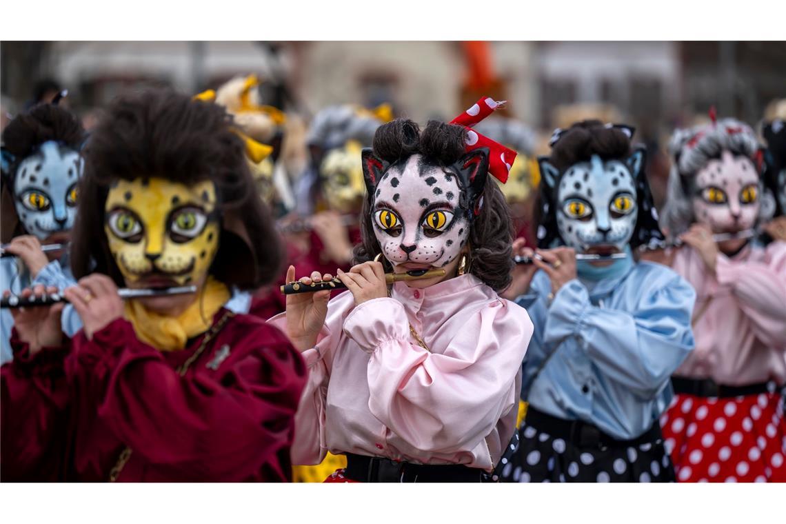 Teilnehmer mit Katzenmasken ziehen beim Fasnachts-Umzug in Basel durch die Straßen.