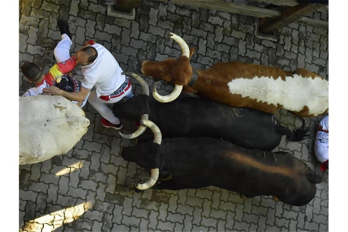 Mehrere verletzte Läufer bei vierter Stierhatz in Pamplona Teilnehmer rennen in der Altstadt von Pamplona vor den Kampfstieren weg. Foto: Alvaro Barrientos/AP