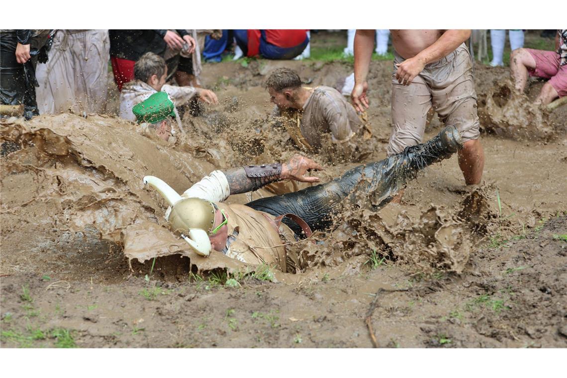 Bilder des Tages Teilnehmer springen auf dem Dreckschweinfest 2025 auf dem Festivalgelände auf der Wildbahn in ein Schlammloch.