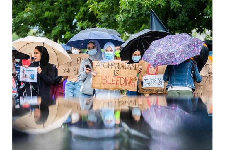 Teilnehmerinnen halten bei einer Demonstration eines breiten Bündnisses für die Aufnahme von Menschen aus Afghanistan vor dem Bundeskanzleramt Schilder. Foto: Christoph Soeder/dpa