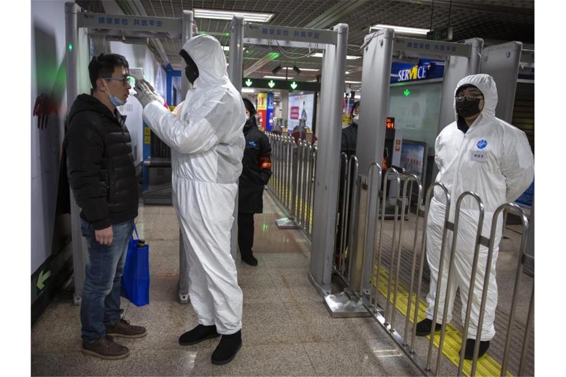 Temperaturkontrollen in einer U-Bahn-Station in Peking. Foto: Mark Schiefelbein/AP/dpa