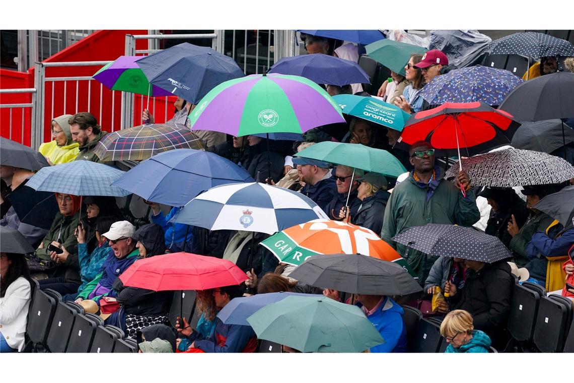 Tennis im Regen: Bei der WTA-Tour in London schützen sich Zuschauer mit Schirmen gegen einen Schauer.