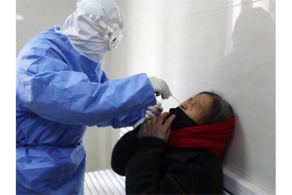 Sars-CoV-2: Erster Patient in Bayern entlassen Test auf das Covid-19-Virus: Ein Arzt nimmt in einer Fieberklinik in der ostchinesischen Provinz Shandong einen Abstrich bei einer Frau. Foto: Uncredited/CHINATOPIX/dpa