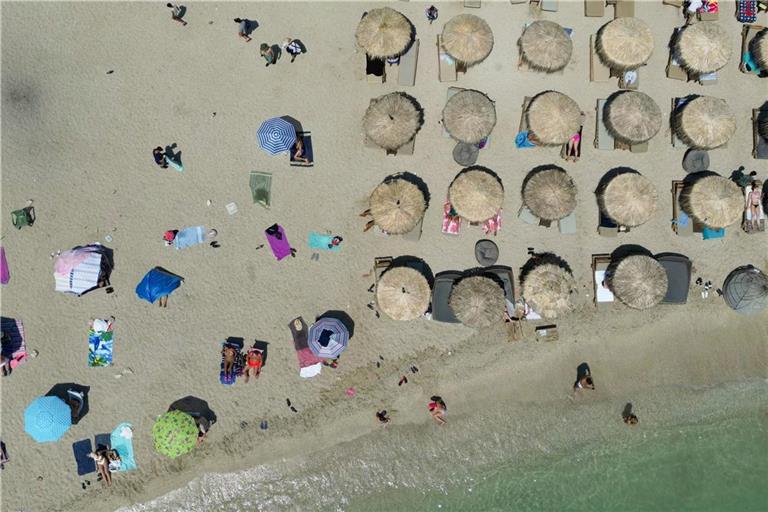 then: Menschen entspannen sich am Strand von Alimos während einer Hitzewelle. Eine Hitzewelle mit Temperaturen von über 40 Grad macht den Menschen in weiten Teilen Griechenlands das Leben schwer.