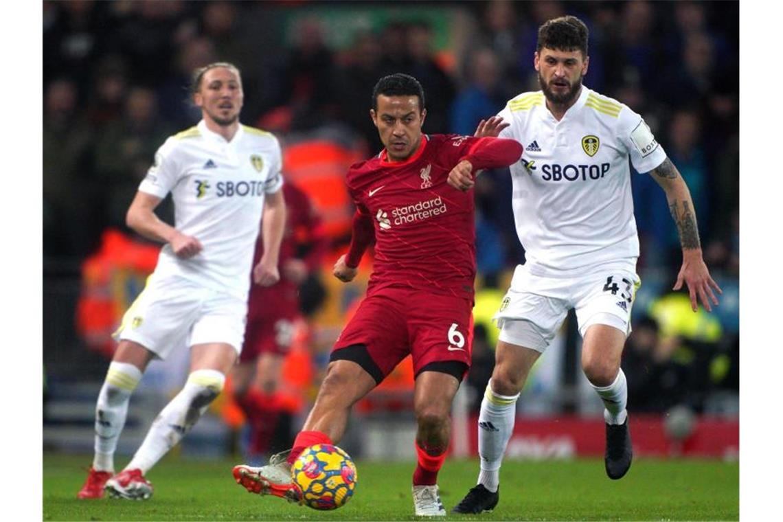 Thiago Alcantara (M) vom FC Liverpool kommt vor Sam Greenwood (r) von Leeds United an den Ball. Foto: Peter Byrne/PA Wire/dpa