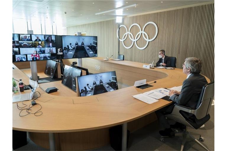 Thomas Bach (r), Präsident des Internationalen Olympischen Komitees (IOC), nimmt an der Sitzung der Exekutive des IOC per Video teil. Foto: Greg Martin/IOC/dpa