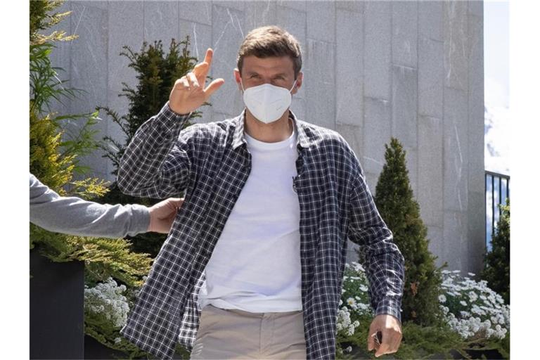 Thomas Müller grüßt bei seiner Ankunft am Hotel Nidum in Österreich. Foto: Christian Charisius/dpa