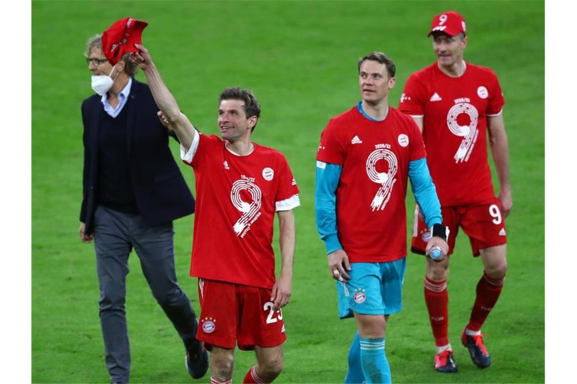 Thomas Müller (l-r), Torwart Manuel Neuer und Robert Lewandowski tragen zu ihrer 9. deutschen Meisterschaft in Folge rote T-Shirts mit einer großen Neun. Foto: Matthias Schrader/AP-Pool/dpa