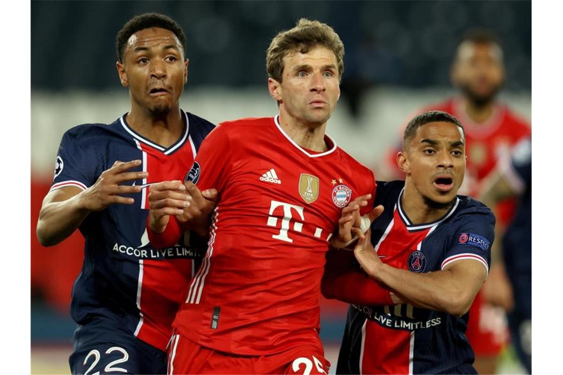 Thomas Müller (M) versucht sich im Parc des Princes Stadion gegen Abdou Diallo (l) durchzusetzen. Foto: Sebastien Muylaert/dpa