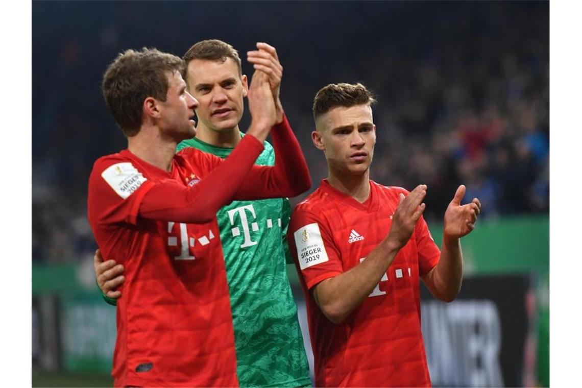 Thomas Müller, Manuel Neuer und Joshua Kimmich feiern den Bayern-Sieg auf Schalke. Foto: Bernd Thissen/dpa