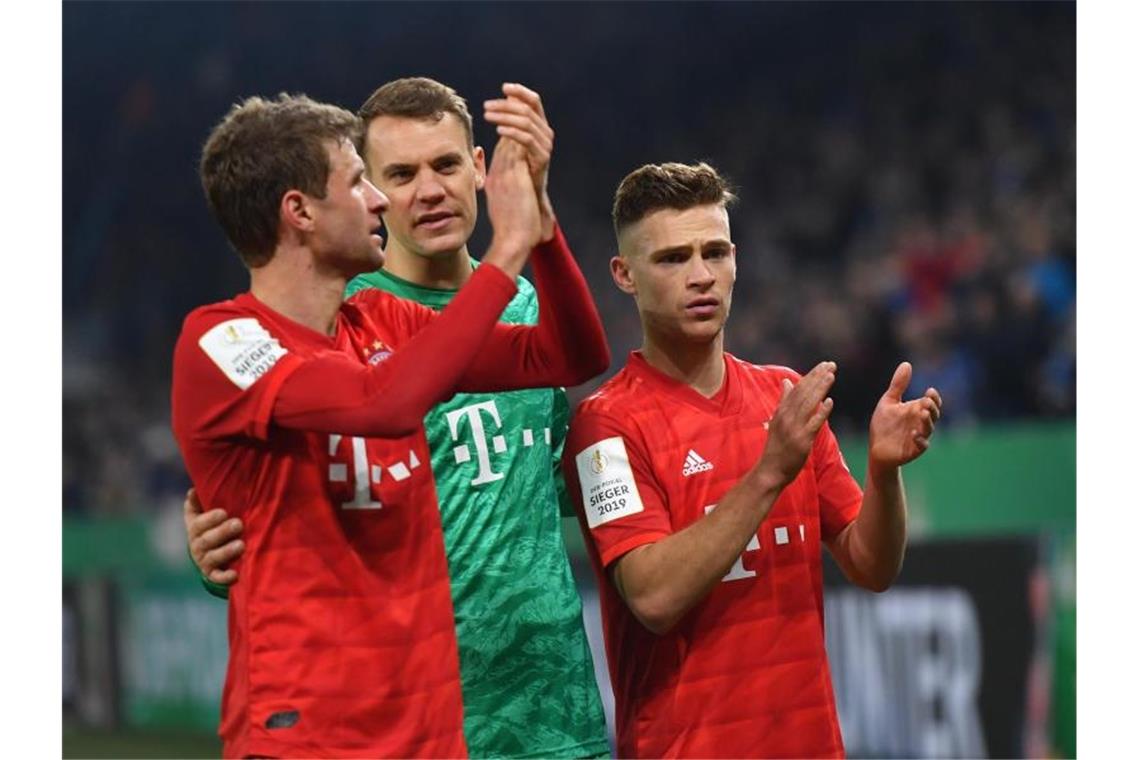 FC Bayern immer mehr wie ein Triple-Kandidat Thomas Müller, Manuel Neuer und Joshua Kimmich feiern den Bayern-Sieg auf Schalke. Foto: Bernd Thissen/dpa