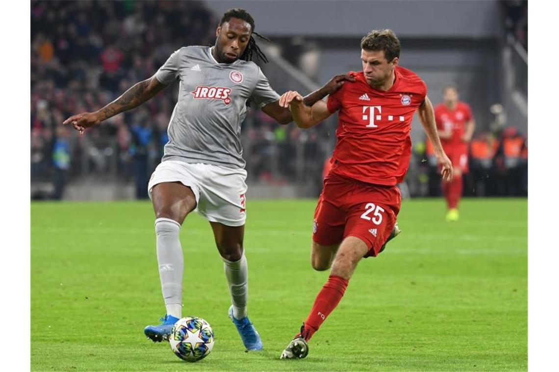 FC Bayern müht sich mit späten Toren ins Achtelfinale Thomas Müller (r) im Duell mit Ruben Semedo von Olympiakos Piräus. Foto: Sven Hoppe/dpa