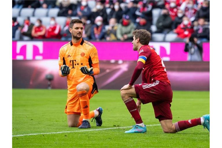 Thomas Müller (r) und Bayern-Torwart Sven Ulreich knien nach dem Eigentor von Müller auf dem Rasen. Foto: Sven Hoppe/dpa