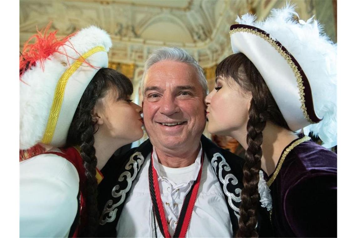 Strobl feiert mit Narren und nimmt Politik aufs Korn Thomas Strobl (CDU, M), Innenminister von Baden-Württemberg, wird im Neuen Schloss von zwei Tanzmariechen geküsst. Foto: Marijan Murat/dpa