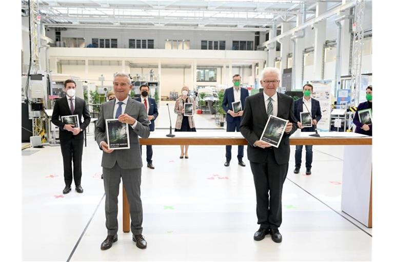 Thomas Strobl (CDU) und Winfried Kretschmann (Grüne) halten den Koalitionsvertrag in den Händen. Foto: Bernd Weissbrod/dpa