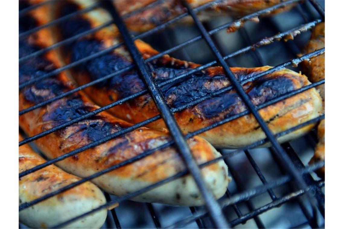 Thüringer Rostbratwürste liegen auf einem Holzkohlegrill. Foto: Hendrik Schmidt/dpa-Zentralbild/dpa/Archivbild