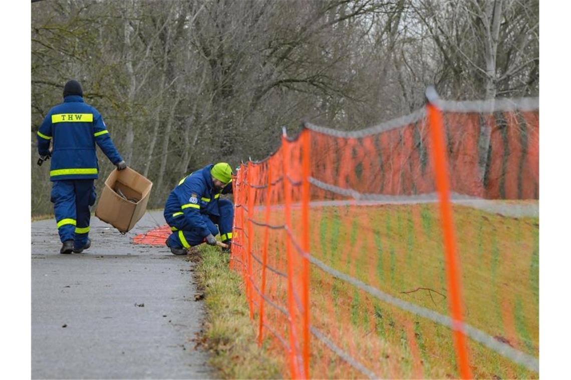 THW-Mitarbeiter errichten im Dezember 2019 nördlich von Frankfurt (Oder) auf dem Deich am deutsch-polnischen Grenzfluss Oder einen provisorischen Schutzzaun gegen die Afrikanische Schweinepest. Foto: Patrick Pleul/dpa-Zentralbild/dpa