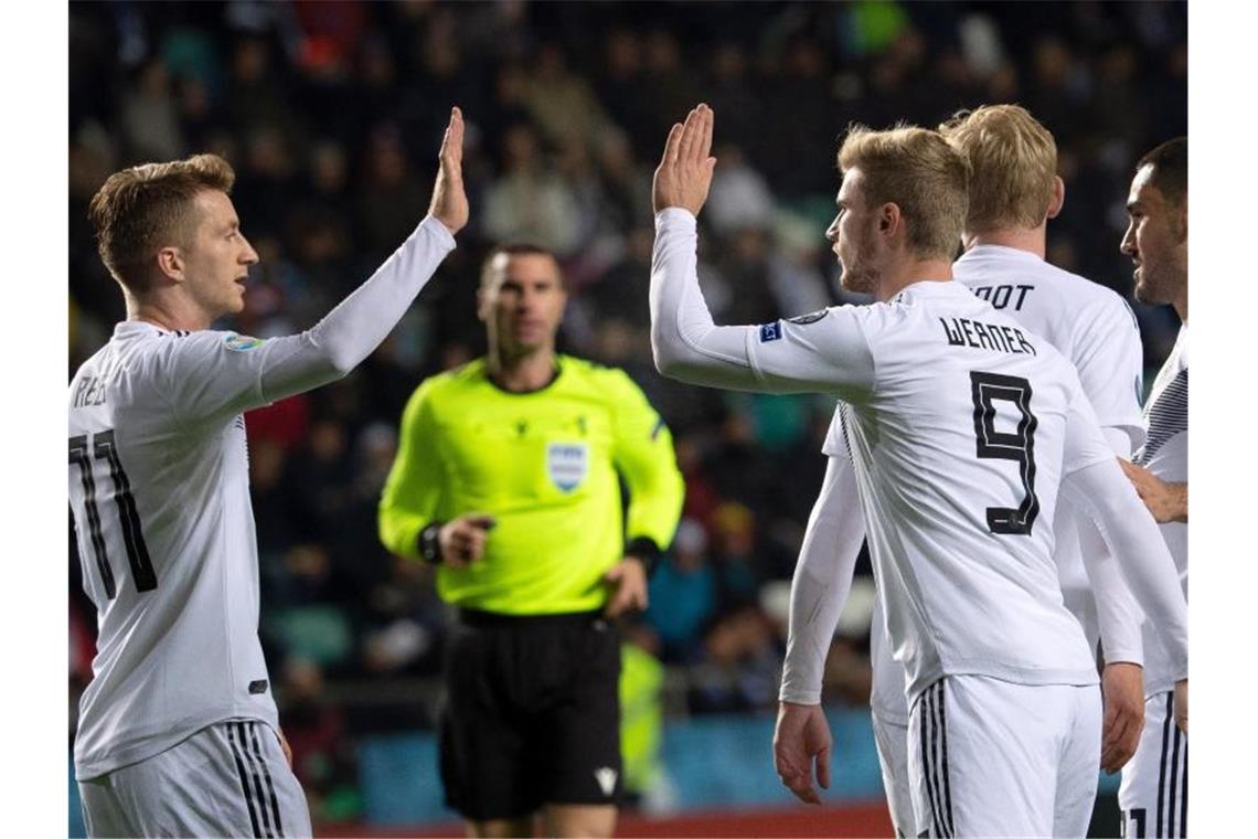 Timo Werner (9) klatscht nach seinem Treffer zum 3:0 mit Marco Reus (l) ab. Foto: Federico Gambarini/dpa