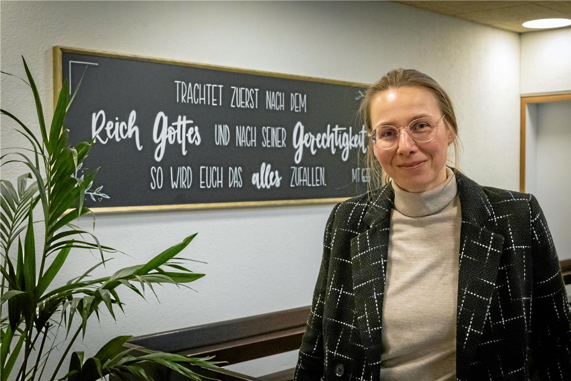 Neue Leiterin der Missionsschule in Weissach Tina Arnold vor der Hauslosung – dem Bibelvers aus der Bergpredigt Jesu, an dem sich die Missionsschule orientiert. Foto: Alexander Becher