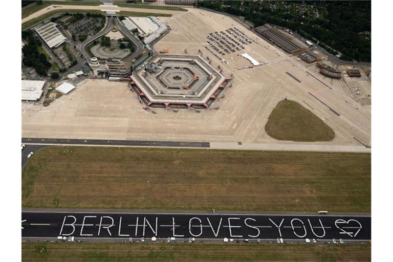 Tische bilden auf der Startbahn des ehemaligen Berliner Flughafens Tegel den Schriftzug „Berlin loves you“. Foto: Christophe Gateau/dpa