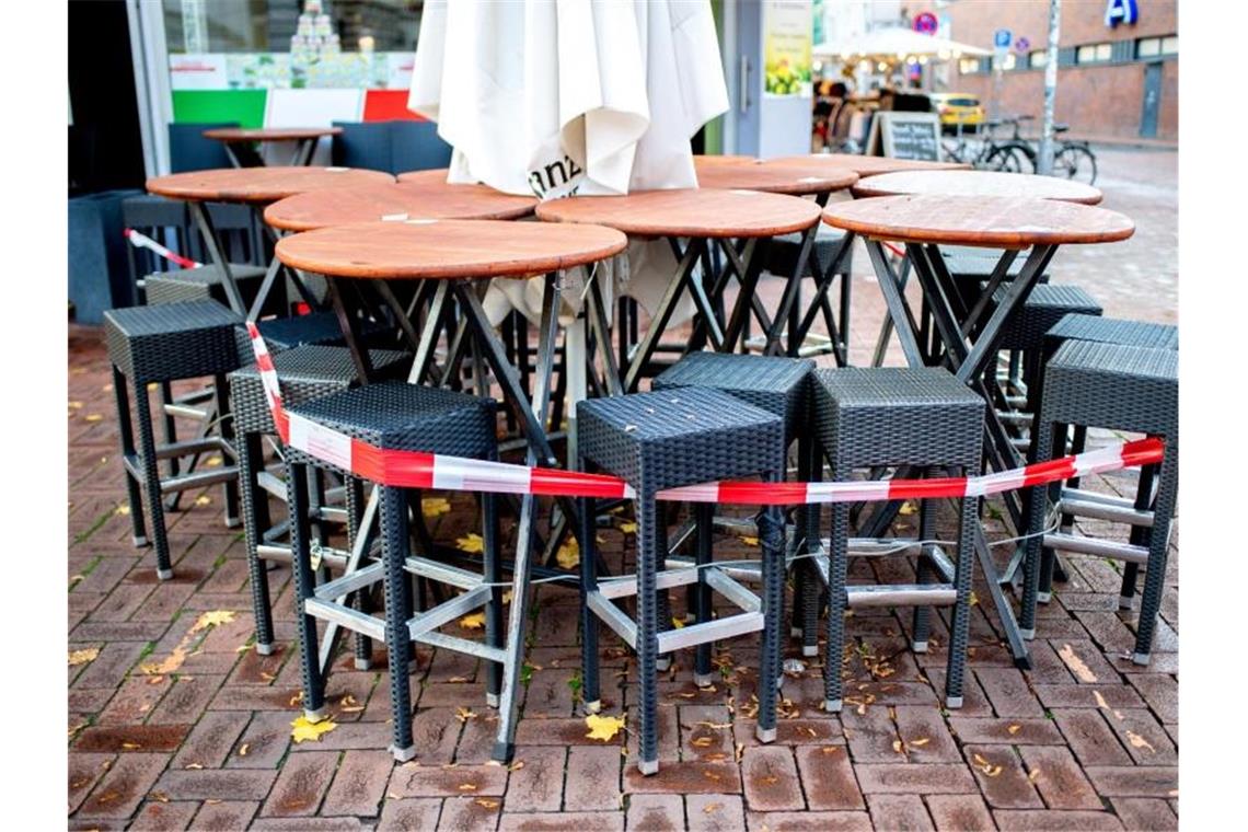 Längerer Teil-Lockdown absehbar - offene Fragen bei Schulen Tische und Stühle stehen abgesperrt vor einer Pizzeria in Hannover. Der von Bund und Ländern beschlossene Teil-Lockdown wird möglicherweise verlängert. Foto: Hauke-Christian Dittrich/dpa