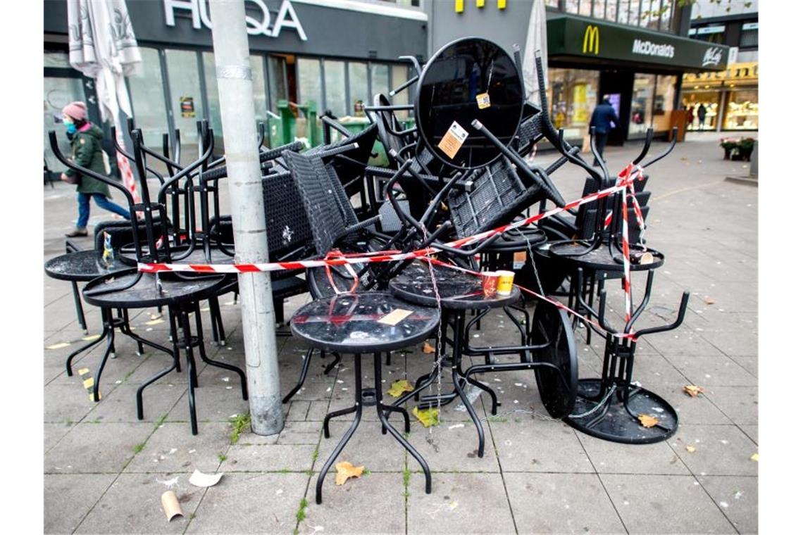 Tische und Stühle stehen vor einem geschlossenen Restaurant. Foto: Hauke-Christian Dittrich/dpa
