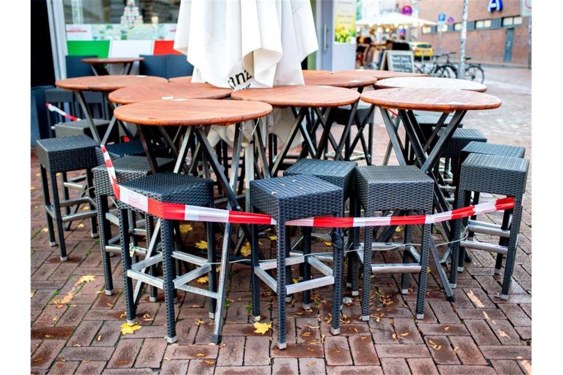 Tische und Stühle stehen vor einer Pizzeria im Hannover. Die Verlängerung des Teil-Lockdowns in Deutschland bis kurz vor Weihnachten ist so gut wie sicher. Foto: Hauke-Christian Dittrich/dpa