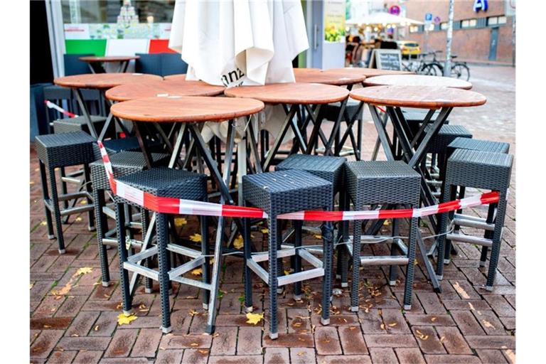 Tische und Stühle stehen vor einer Pizzeria im Hannover. Die Verlängerung des Teil-Lockdowns in Deutschland bis kurz vor Weihnachten ist so gut wie sicher. Foto: Hauke-Christian Dittrich/dpa