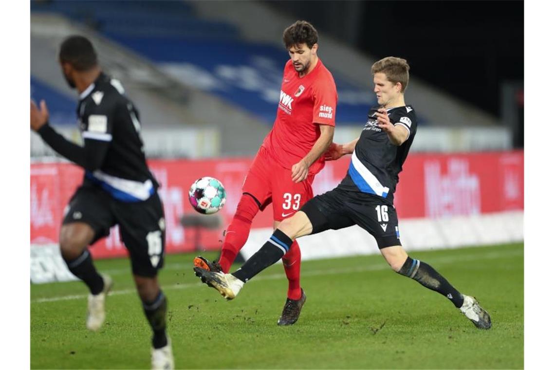 Derbysieger Leverkusen weiter Erster - Bayern bezwingt VfL Tobias Strobl (M) konnte mit Augsburg drei Punkte aus Bielefeld mitnehmen. Foto: Friso Gentsch/dpa