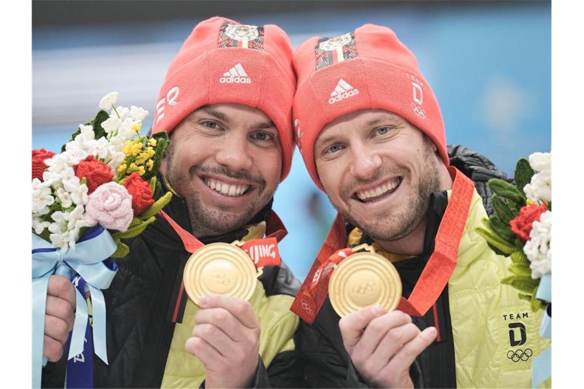 Arm in Arm: Rodel-Doppelsitzer Wendl/Arlt feiern Gold-Triple Tobias Wendl (l) und Tobias Arlt präsentieren freudestrahlend ihre Goldmedaillen. Foto: Michael Kappeler/dpa