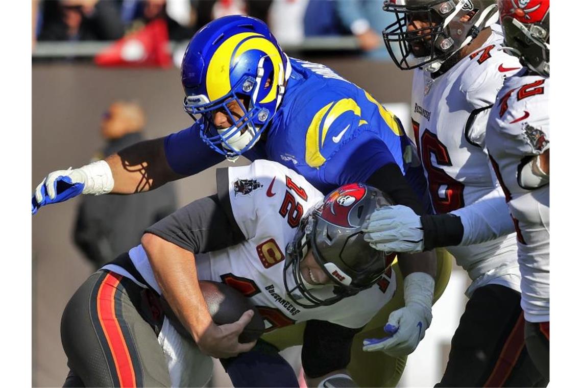 NFL-Superstar Brady raus aus den Playoffs: War's das, Tom? Tom Brady, Quarterback der Tampa Bay Buccaneers, wird von End Aaron Donald von den Los Angeles Rams zu Fall gebracht. Foto: Mark Lomoglio/AP/dpa