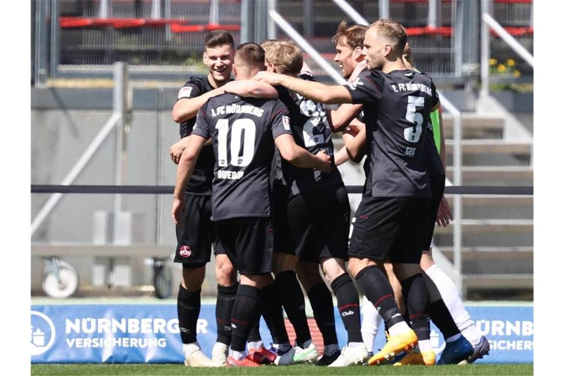 Tom Krauß (l) vom 1. FC Nürnberg freut sich mit seinen Mannschaftskollegen über seinen Treffer zum 3:1. Foto: Daniel Karmann/dpa