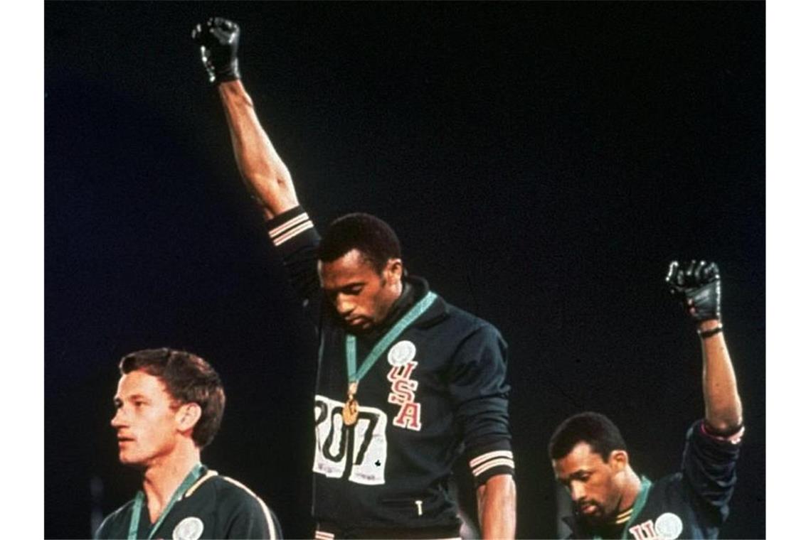 Tommie Smiths (M.) erhobene Faust auf dem Siegerpodest ist noch immer das Symbol des friedlichen Protests gegen Rassismus. Foto: Anonymous/AP/dpa