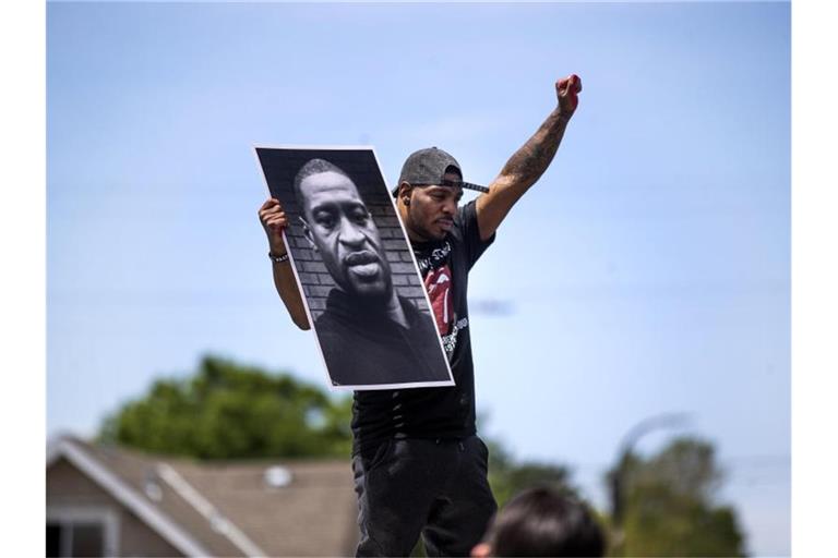 Tony L. Clark hält ein Foto des verstorbenen George Floyd. Der ehemalige Polizist Derek Chauvin ist des Mordes schulig gesprochen worden. Foto: Jerry Holt/Star Tribune/AP/dpa