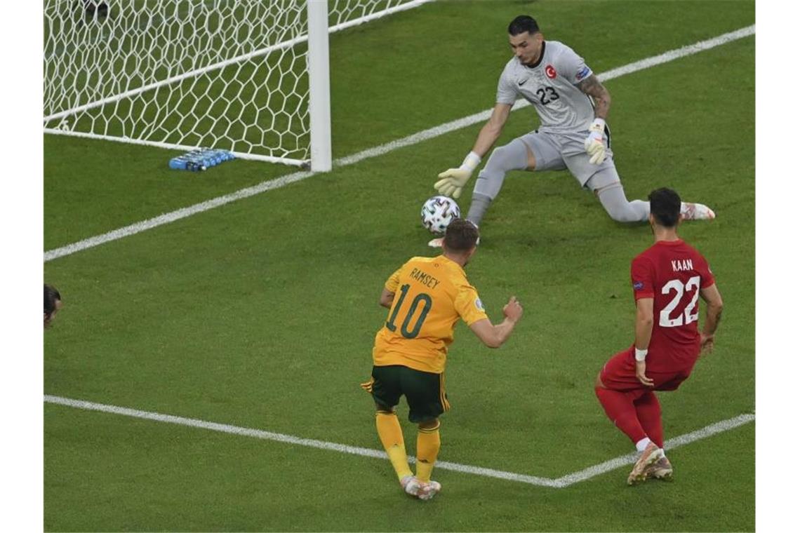 Torhüter Ugurcan Cakir (oben) kann einen Schuss des Walisers Aaron Ramsey (M) abwehren. Foto: Dan Mullan/Getty-Pool/AP/dpa