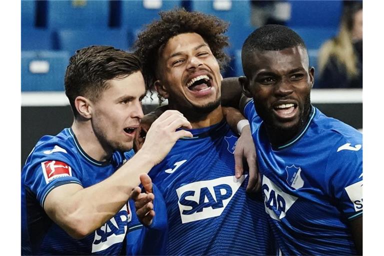 Torschütze Georginio Rutter (M) freut sich mit Christoph Baumgartner (l) und Ihlas Bebou über das Tor zum 2:0. Foto: Uwe Anspach/dpa