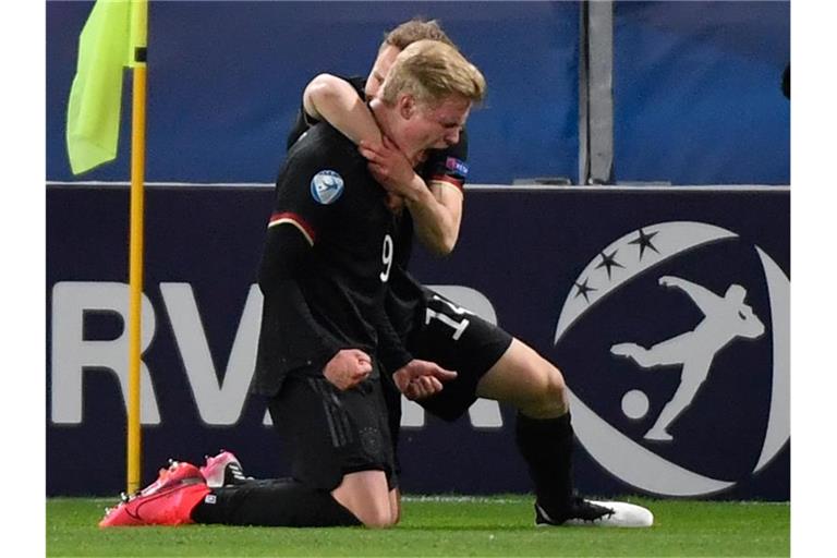 Torschütze Jonathan Burkardt und Teamkollege Paul Jaeckel (hinten) feiern das 1:2 gegen Dänemark. Foto: Marton Monus/dpa