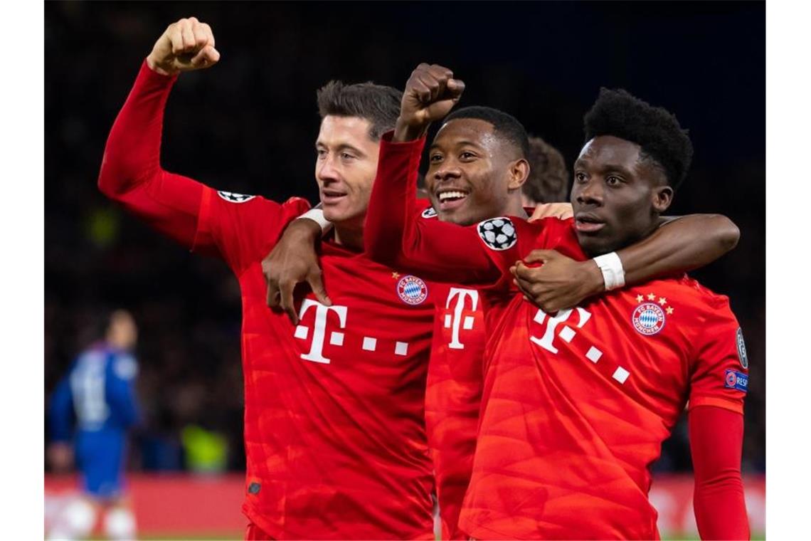 Torschütze Robert Lewandowski (l-r), David Alaba und Alphonso Davies jubeln über das 3:0 in London. Foto: Sven Hoppe/dpa