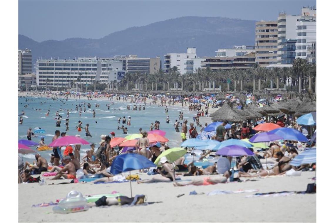 Mallorca hebt fast alle Corona-Einschränkungen auf Touristen am Strand von Arenal. Corona-Reisebeschränkungen werden auf Mallorca deutlich gelockert oder fallen ganz. Foto: Clara Margais/dpa