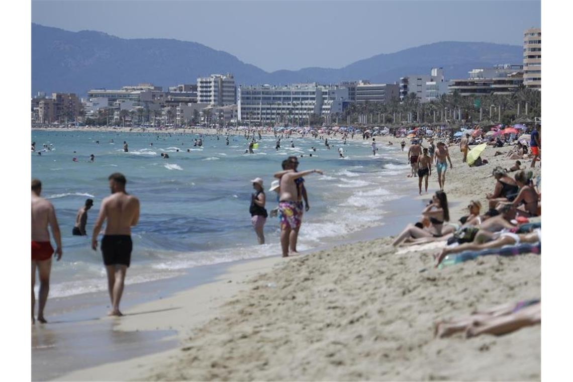 Touristen am Strand von Arenal in Palma de Mallorca - trotz steigender Corona-Zahlen. Foto: Clara Margais/dpa