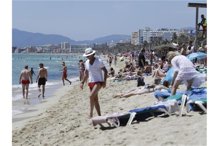 Touristen am Strand von Arenal nahe Palma de Mallorca. Foto: Clara Margais/dpa